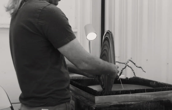 A glass artist finishing his piece in the cold shop.